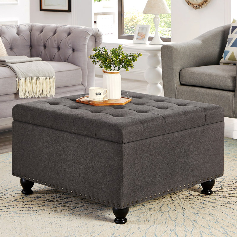 Grand repose-pieds de rangement carré avec pieds en bois, table basse capitonnée avec garniture cloutée, Gris foncé