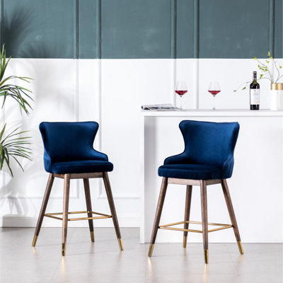 2 tabourets de bar bleus à dossier enveloppant, revêtement en tissu, mousse haute densité, pieds en noyer, métal et placage or, style mi-siècle, intérieur en velours.