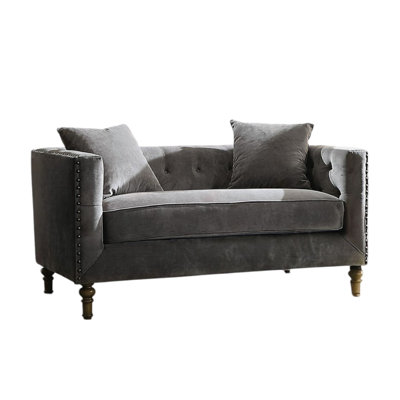 Fauteuil en velours gris avec coussins, boutons et accoudoirs, garniture cloutée, dossier haut enveloppant, pieds tournés en bois, capacité de charge de 100 kg, hauteur d'assise intérieure de 56 cm, profondeur du produit de 86 cm