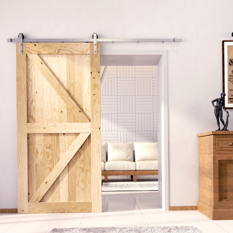 Une porte de grange en bois de pin massif non fini / non assemblé avec une quincaillerie d'installation en nickel brossé