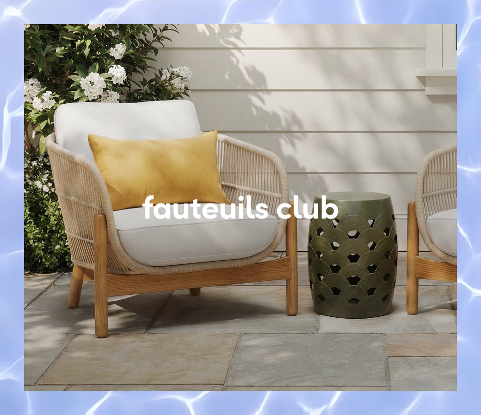 Un fauteuil club d extérieur tressé avec des coussins blancs et un coussin lombaire jaune à côté d un tabouret de jardin en céramique verte.