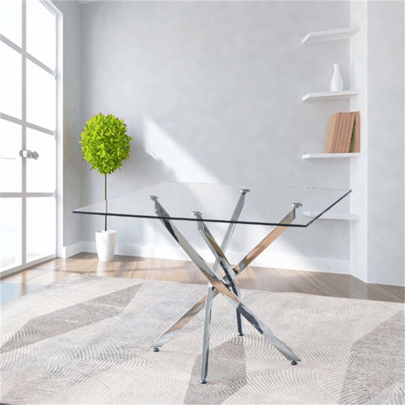 Table carrée contemporaine en verre trempé transparent avec pieds élégants en acier inoxydable à finition argentée, parfaite pour les intérieurs modernes et les espaces compacts.