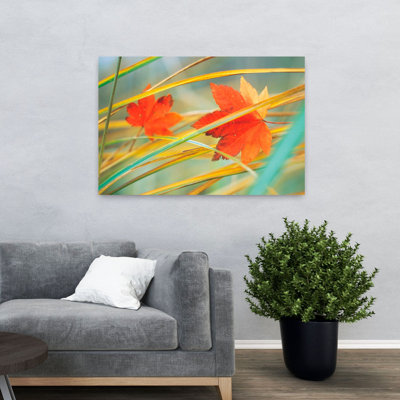 Deux feuilles d'automne orange sur fond de roseaux jaunes sur fond vert abstrait érable contemporain automne art naturel