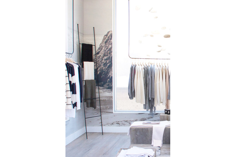 A trendy clothing ladder with scarves draped on it in a retail store.