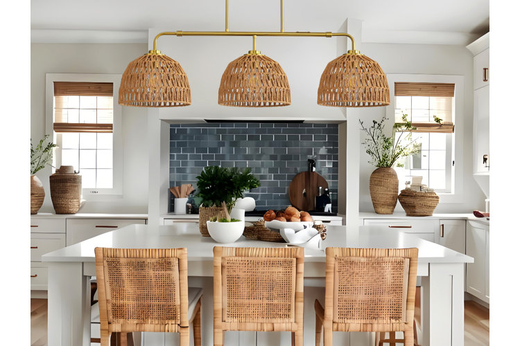 Modern kitchen with three rattan counter stools pulled up to a white kitchen island, and rattan pendant light above.
