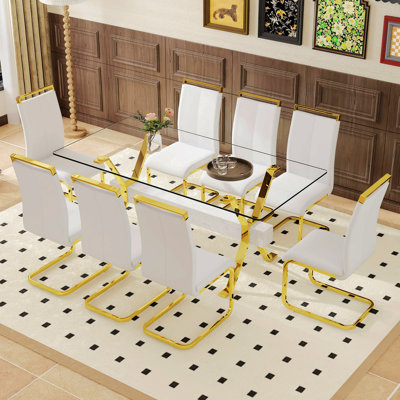 Ensemble de table et de chaises. Ensemble de salle à manger élégant en verre trempé transparent - 71 po x 35,4 po avec 8 chaises en polyuréthane et pieds en C en tube d'or.