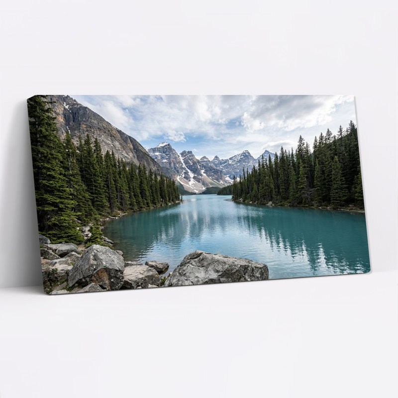 Tableau sur toile représentant des sommets enneigés et une forêt de pins le long d'un lac turquoise, L 40 po x H 20 po