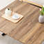 Table relevable moderne en bois texturé de 2 cm d'épaisseur, pattes en métal noir, aspect naturel, idéale pour le café, les repas et le travail. Montage facile et polyvalent, hauteur réglable.