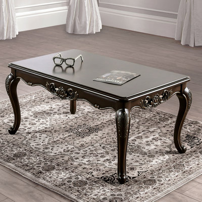 Table basse de style traditionnel avec pieds courbés et structure sculptée en bois massif