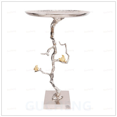 Table d'appoint ronde en aluminium avec des branches inspirées de la nature et des accents d'oiseaux exquis, parfait pour un décor moderne et éclectique