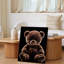 Toile, un ours en peluche moelleux repose sur un fond d'art mural noir profond qui évoque une présence chaleureuse et invitante-744615624