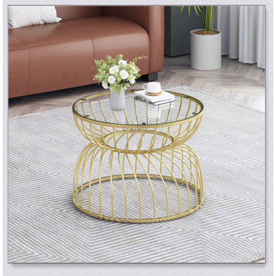 Table basse dorée avec plateau en verre trempé transparent et cadre en métal élégant, parfait pour les espaces de vie modernes.