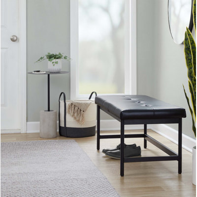 Banc moderne en métal noir avec siège rembourré en similicuir noir pour un confort durable et une assise peu encombrante.