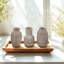 S / 3 petits vases de sable et de ciment brun avec motifs sculpturaux A: 3,7 x 3,7 x 6 po B: 3,5 x 3,5 x 6 po C: 3,7 x 3,7 x 6 po
