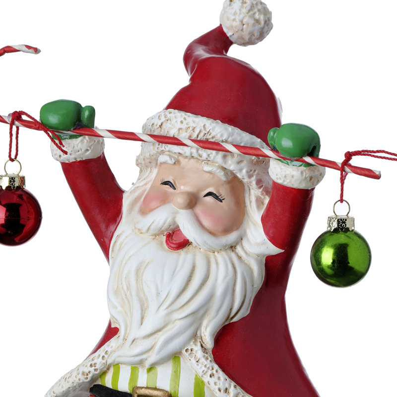Figurine de père Noël tenant une canne en bonbon avec boules