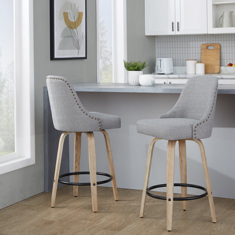 Tabouret de comptoir 27 po à hauteur fixe avec pivot en bois blanchi et tissu gris clair avec garniture cloutée en laiton et repose-pieds rond en métal noir - ensemble de 2
