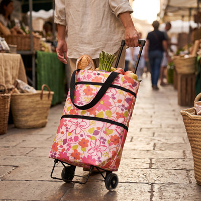 Sac fourre-tout pliable à roulettes avec motif floral, idéal pour faire ses courses en voyage.