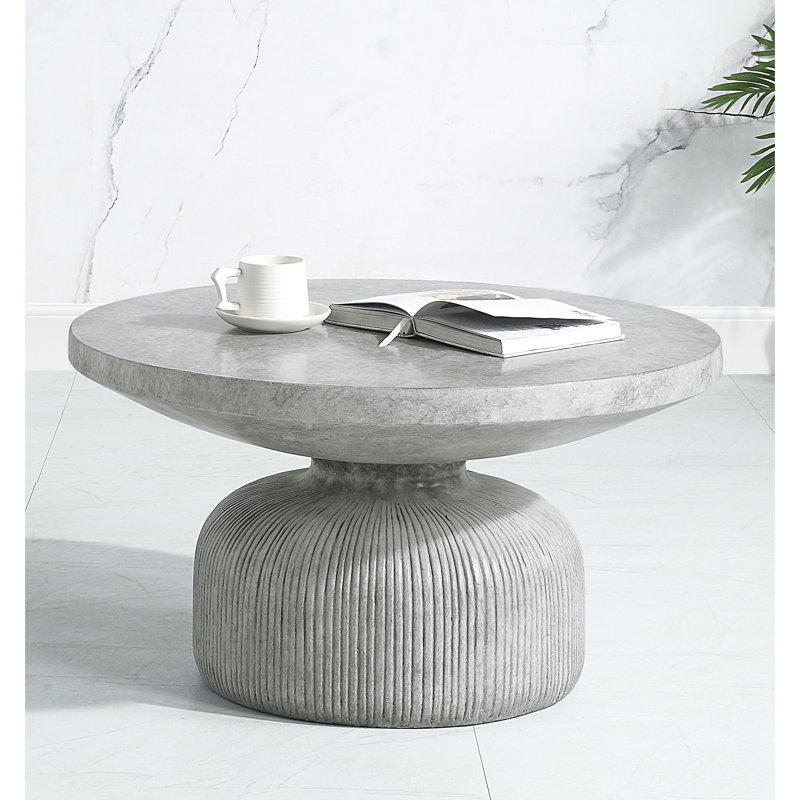 Table basse distinctive en ciment gris patiné, ronde, avec piédestal séduisant