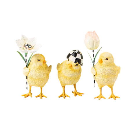 Three decorative yellow chicks holding flowers, one wearing a Courtly Check egg hat.