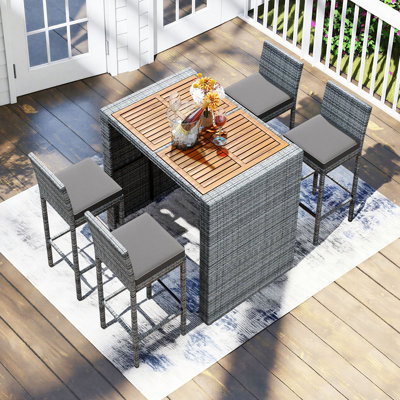 Ensemble de salle à manger de bar 5 pièces avec cadre en osier de patio, tabouret de bar avec dossier, plateau de table en bois d'acacia et coussins amovibles