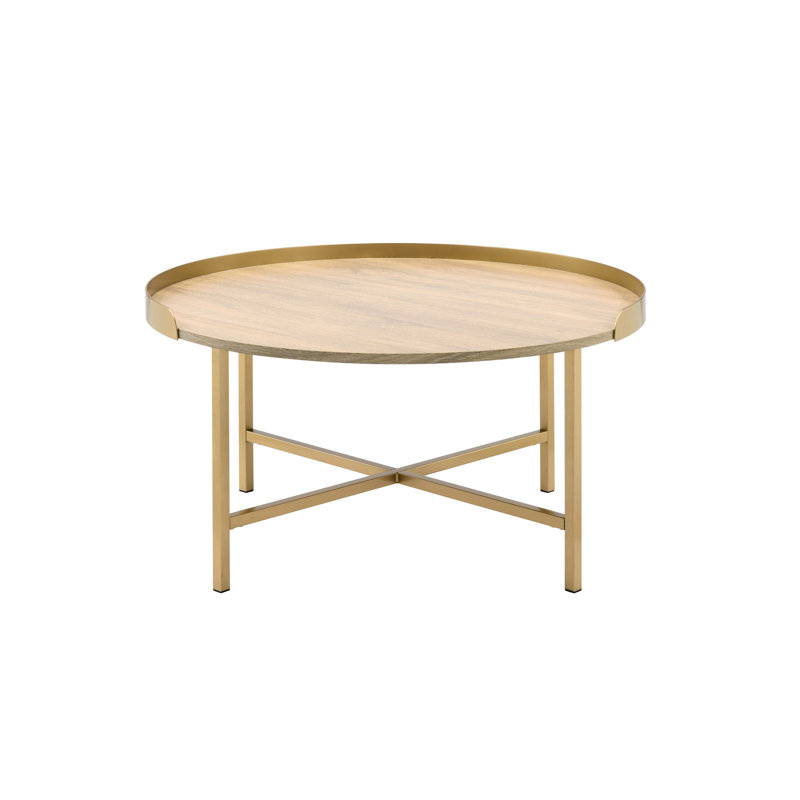 Table basse contemporaine en chêne et or présentant un plateau rond et une base en métal avec barre transversale