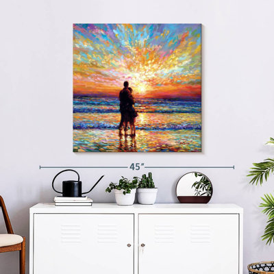 Couple à la plage au coucher du soleil