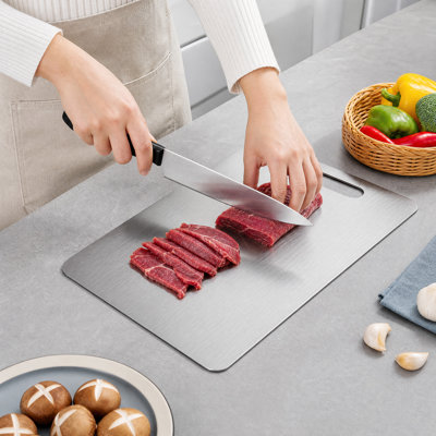 Planche à découper en acier inoxydable, facile à nettoyer, compatible au lave-vaisselle, durable et élégante avec son design argenté.