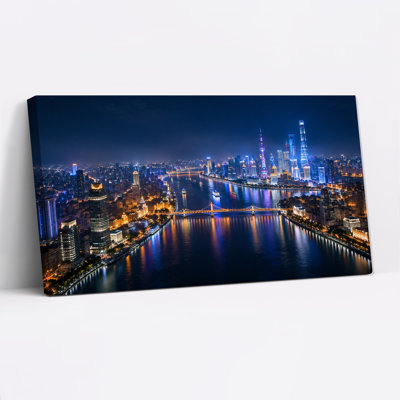 Illuminated City Skyline Over River At Night With Bridges Canvas Wall Art