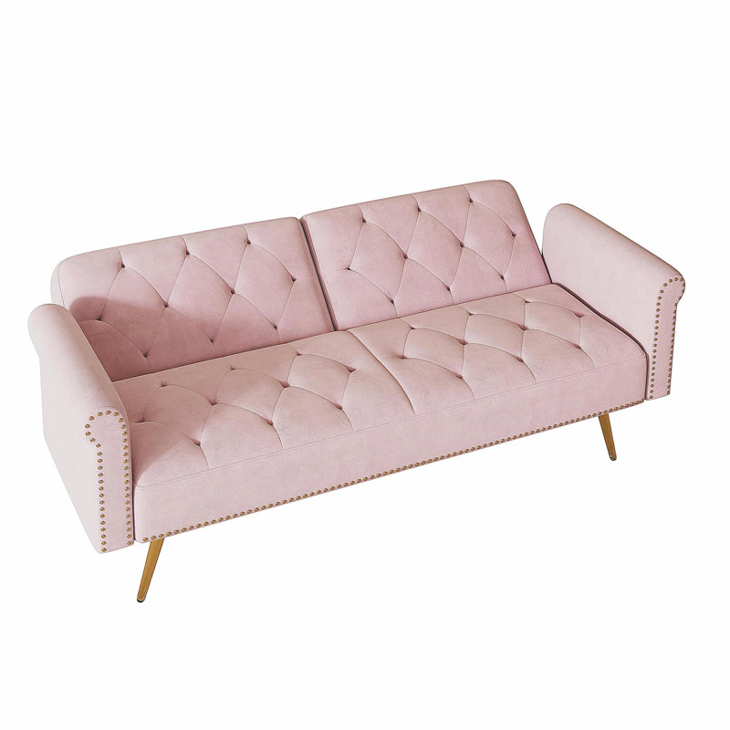 Un canapé-lit de 69,7 pouces de long recouvert de velours rose, doté d'une garniture cloutée et d'un coussin décoratif assorti