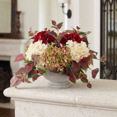 Assortiment d'hortensias et de lierre disposés dans un pot en pierre
