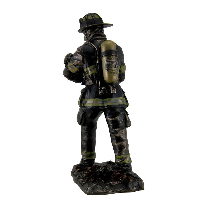 Statue traditionnelle en résine coulée à froid, représentant un pompier portant un enfant, en bronze métallisé, hauteur 28 cm.