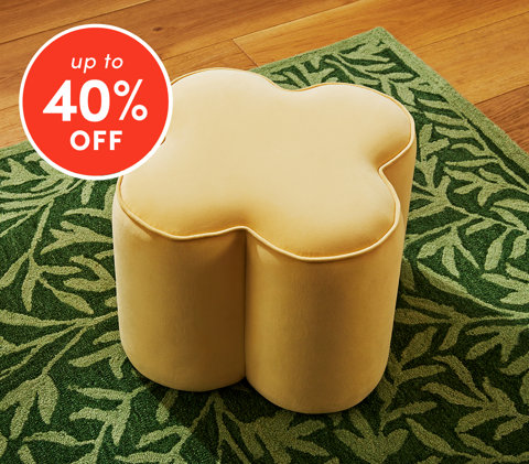 Ottomans up to 40% off featuring yellow clover-shaped velvet ottoman on green leaf pattern rug