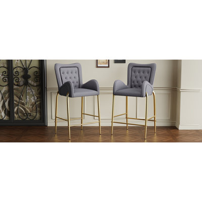 Élégants tabourets de bar en velours avec pieds et repose-pieds dorés, offrant confort et élégance pour votre maison.