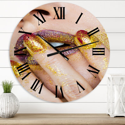 Gros plan sur un rouge à lèvres doré à paillettes dorées - horloge murale moderne