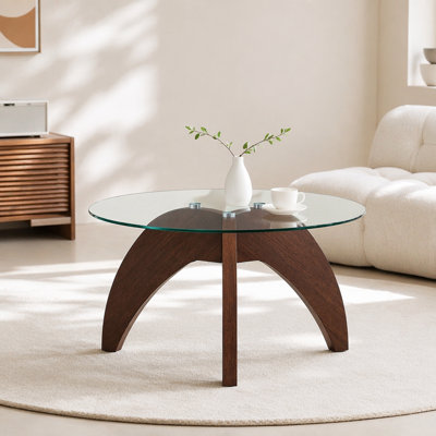 Table basse créative de style triangulaire à pattes rondes, d'environ 27,5 pouces de diamètre, avec plateau en verre trempé transparent et panneau de fibres à densité moyenne de couleur noyer. Parfait comme table basse de salon, etc.