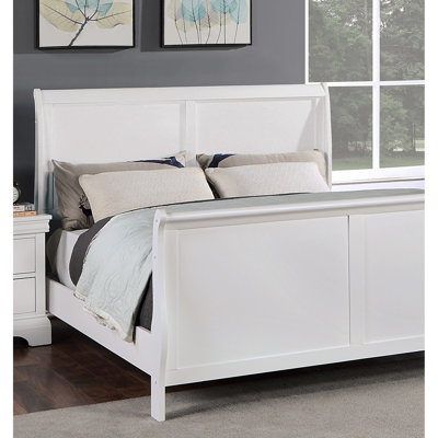 Structure de lit grand format avec tête de lit en contreplaqué blanc et base dans la chambre à coucher