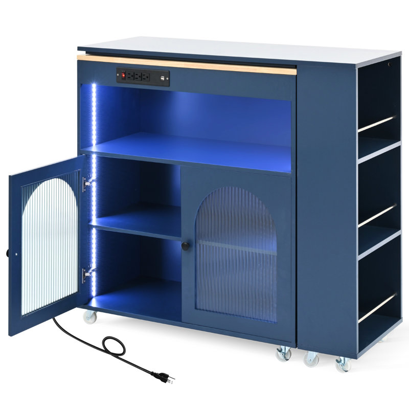 Îlot de cuisine moderne avec table allongée, rangement roulant à lumières DEL bleu marine, prise de courant, porte en verre cannelé et grande capacité,