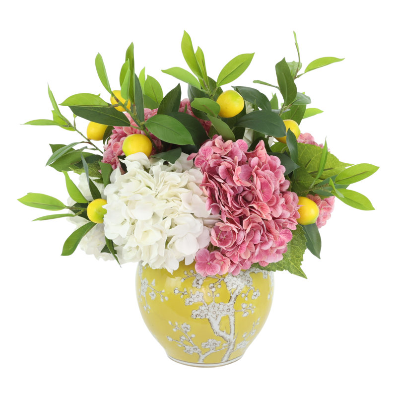 Arrangement d'hortensias et de citrons dans un vase décoratif en céramique