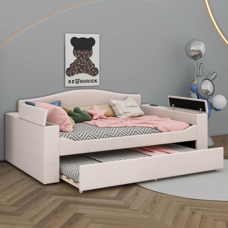Un lit de jour rembourré avec accoudoirs de rangement, un lit gigogne sous le lit et un système audio Bluetooth de pointe