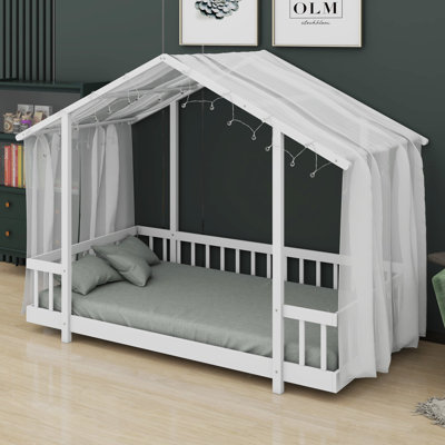 Platform bed with house-shaped canopy and string lights brings storybook charm to a child's bedroom