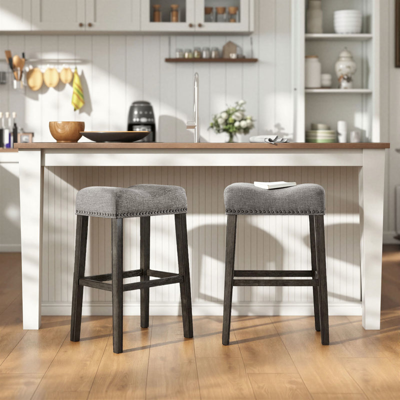Tabourets de bar sans dossier Oenone, siège de selle rembourré avec garniture cloutée, pieds en bois patiné - ensemble de 2
