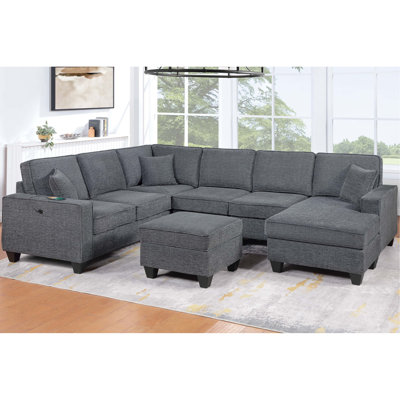 Canapé d'angle contemporain 5 pièces comprenant un accoudoir gauche, un accoudoir droit avec méridienne, un angle droit, un fauteuil sans accoudoirs et un pouf pour l'espace salon principal.