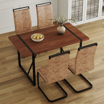 Ensemble de table et de chaises. Une table de salle à manger rectangulaire rétro minimaliste avec un dessus spécialement texturé et des pieds en métal noir, jumelée à 4 chaises douces et des pieds en métal noir, met en valeur un beau style de maison.