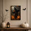 Chat noir portant un chapeau de sorcière avec une décoration d'Halloween Jack O-132430442