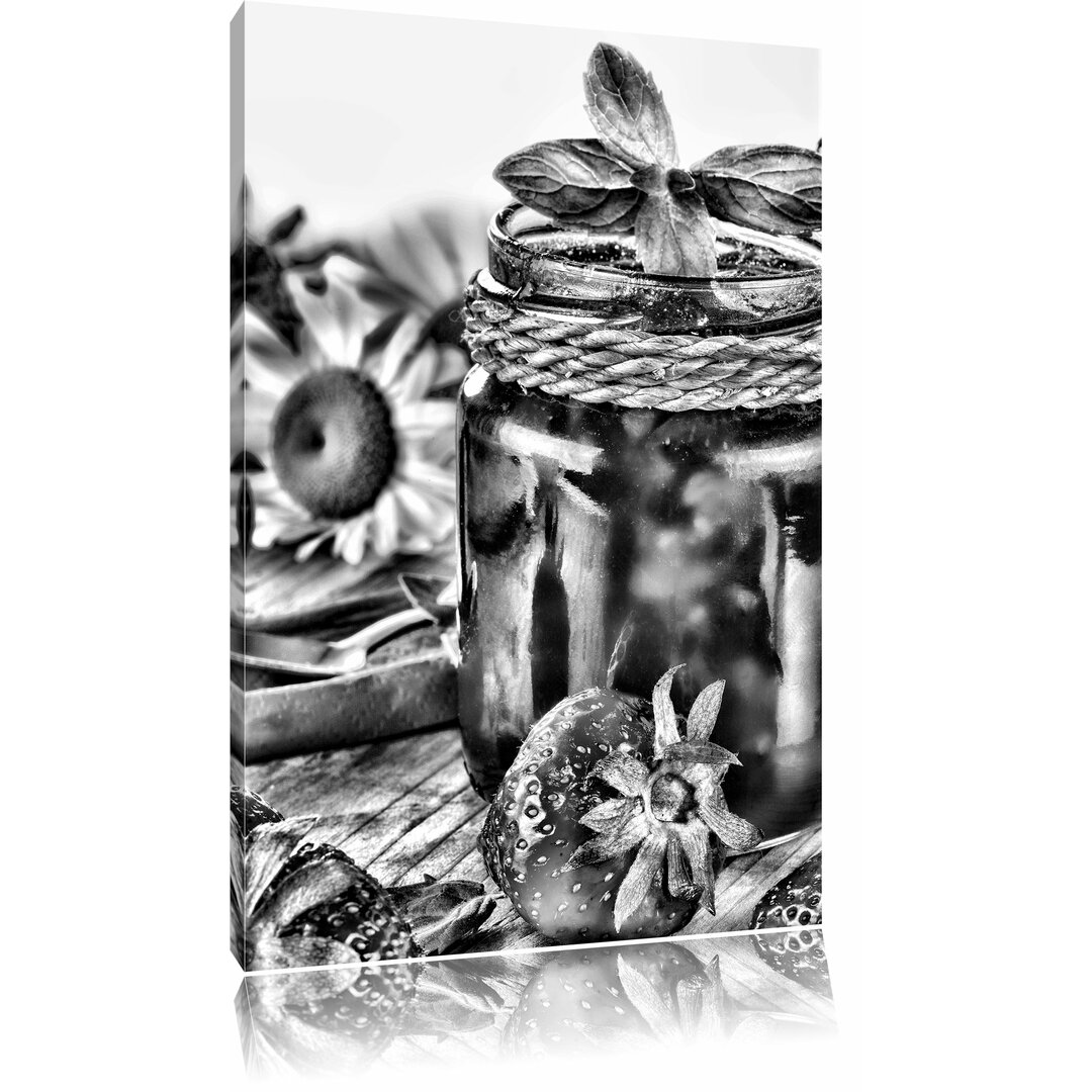 Leinwandbild Glas mit Erdbeeren in Wiese voller Klee in Monochrom