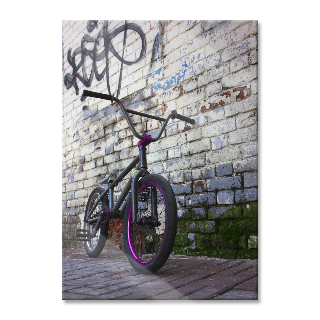 Glasbild Fahrrad vor Graffitiwand