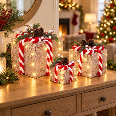 Coffrets cadeaux roses pailletés en 3 pièces avec pommes de pin, accents de cannes de Noël rouges et blanches et feuillage persistant pour la décoration de Noël