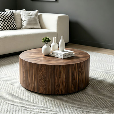 Table basse cylindrique compacte Brayden Studio en noyer foncé, idéale pour les salons et les appartements.