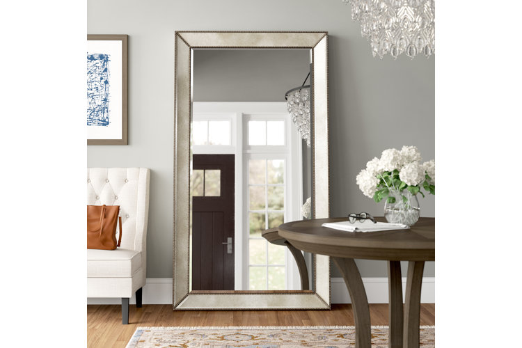 Oversized floor-length mirror with a silver frame.