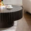 Table basse ronde avec relief fabriqué à la main et piédestal robuste, parfaite pour les salons modernes et élégants